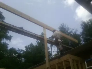 Carpenter setting a ridge beam over a new addition frame — Ice Dam Removal by Roofing Brothers in Middlesex